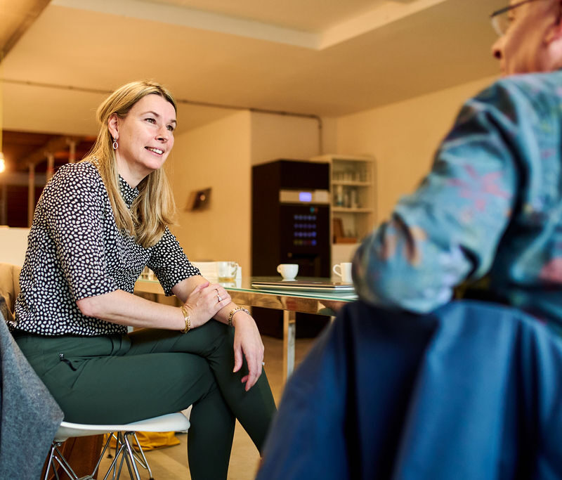 Twee personen zijn met elkaar in gesprek aan een tafel